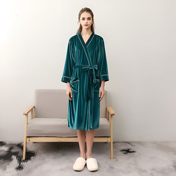 Femme portant un kimono vert en velours. Peignoir élégant avec ceinture et poches. Vêtements d'intérieur confortables pour se détendre à la maison. Découvrez notre collection de kimonos de luxe.