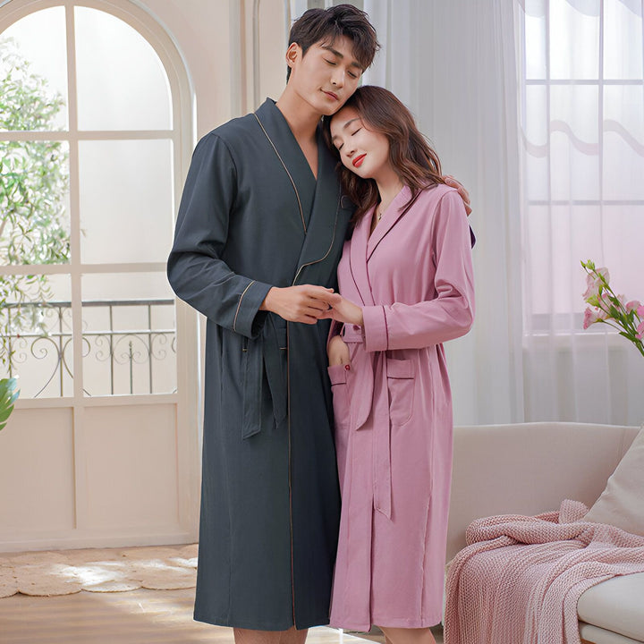 Couple portant des kimonos assortis. Homme en kimono gris, femme en kimono rose. Confort et élégance pour votre intérieur. Découvrez notre collection de kimonos.