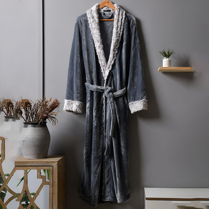 Peignoir kimono gris en tissu doux avec garniture en fausse fourrure blanche, suspendu à un cintre. Idéal pour se détendre avec style. Disponible dans notre boutique en ligne.