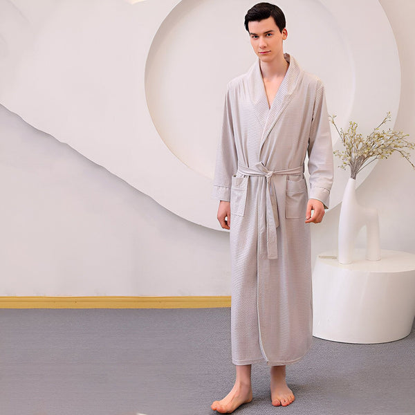 Homme portant un long kimono gris clair avec ceinture, disponible chez notre boutique de kimonos. Parfait comme vêtement de détente ou peignoir.