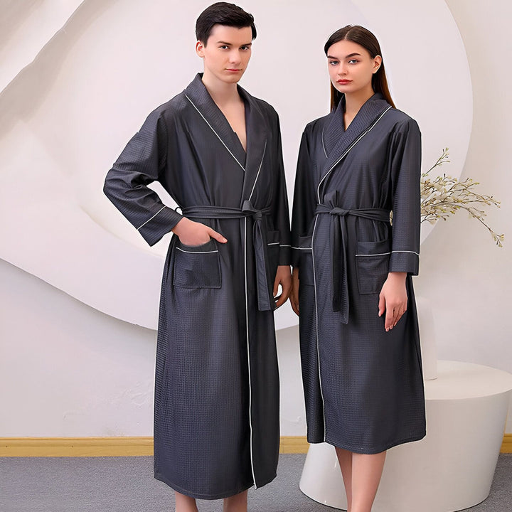 Couple portant des kimonos assortis gris anthracite avec bordure blanche et ceinture. Kimonos confortables et élégants disponibles à l'achat.