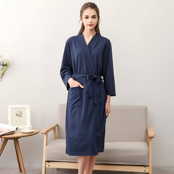 Femme portant un kimono bleu marine avec ceinture. Kimono de luxe pour la maison et le spa. Vêtements d'intérieur confortables et élégants. Achetez nos kimonos de haute qualité en ligne.