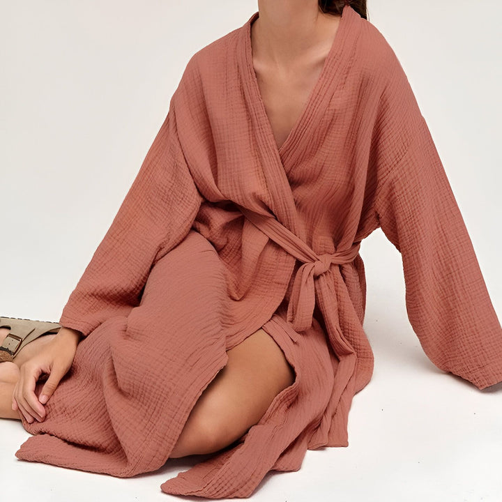 Femme portant un kimono en coton rose saumon. Kimono confortable et élégant, idéal pour la détente. Découvrez notre collection de kimonos uniques.