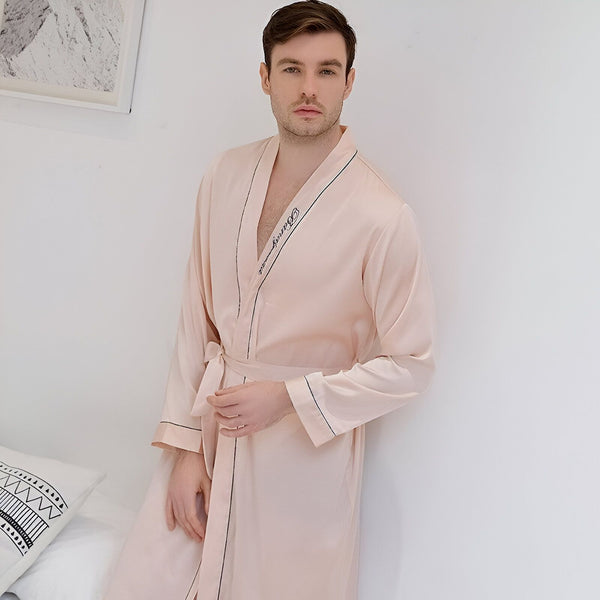 Homme portant un kimono rose clair avec ceinture. Peignoir élégant, confortable, idéal pour la détente. Vêtements d'intérieur de luxe.