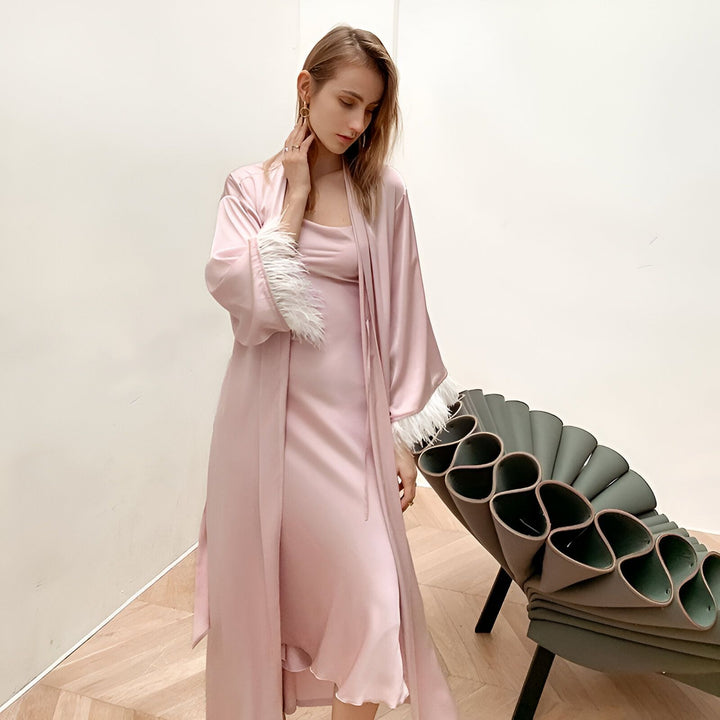 Femme portant un kimono rose en soie avec bordure en plumes blanches. Vente de kimonos de qualité.
