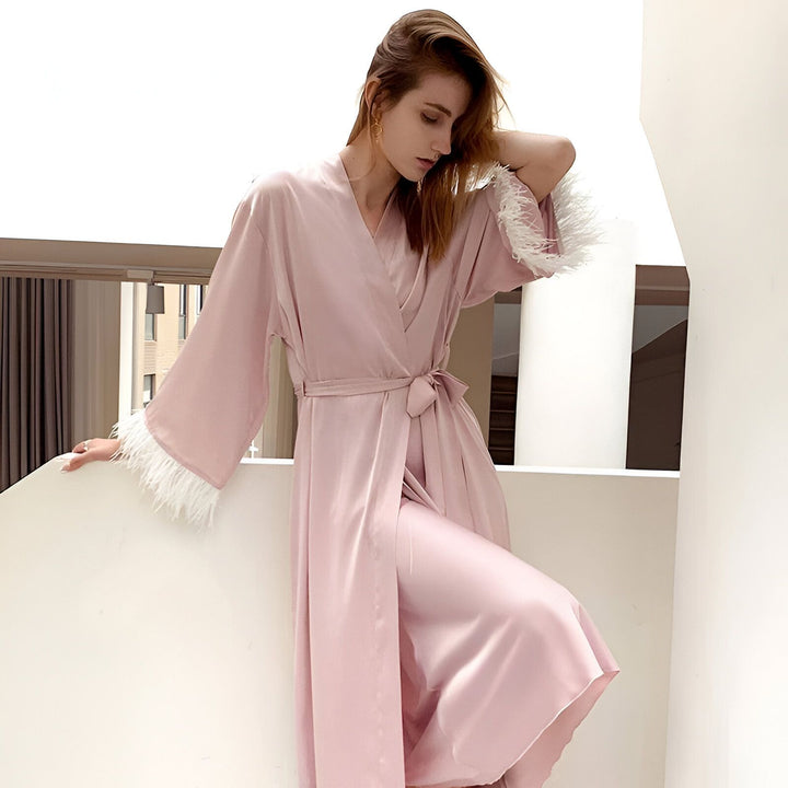 Femme portant un kimono rose avec des plumes blanches aux poignets. Kimonos élégants à acheter en ligne.