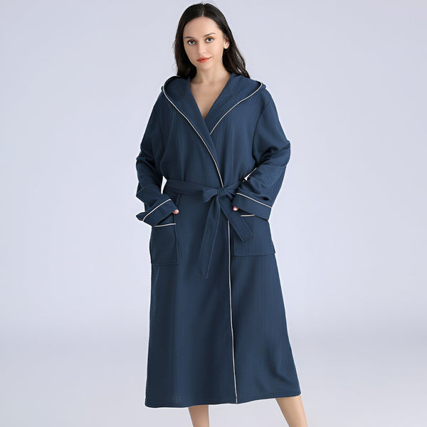 Femme portant un kimono bleu marine à capuche avec ceinture. Peignoir long et confortable, idéal pour se détendre à la maison. Vêtement de détente, style kimono.
