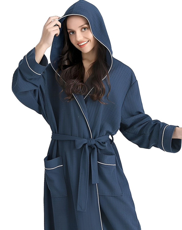 Femme portant un kimono bleu marine avec capuche et ceinture. Peignoir confortable, idéal pour la détente. Vêtements de style japonais de notre boutique.