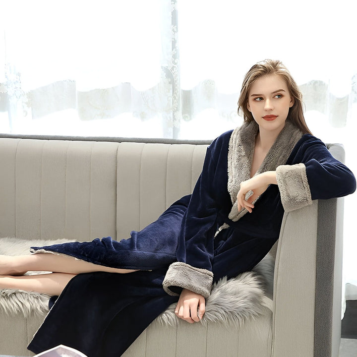 Femme portant un kimono bleu marine moelleux avec doublure en fausse fourrure grise. Kimono confortable parfait pour se détendre à la maison. Disponible chez nous.