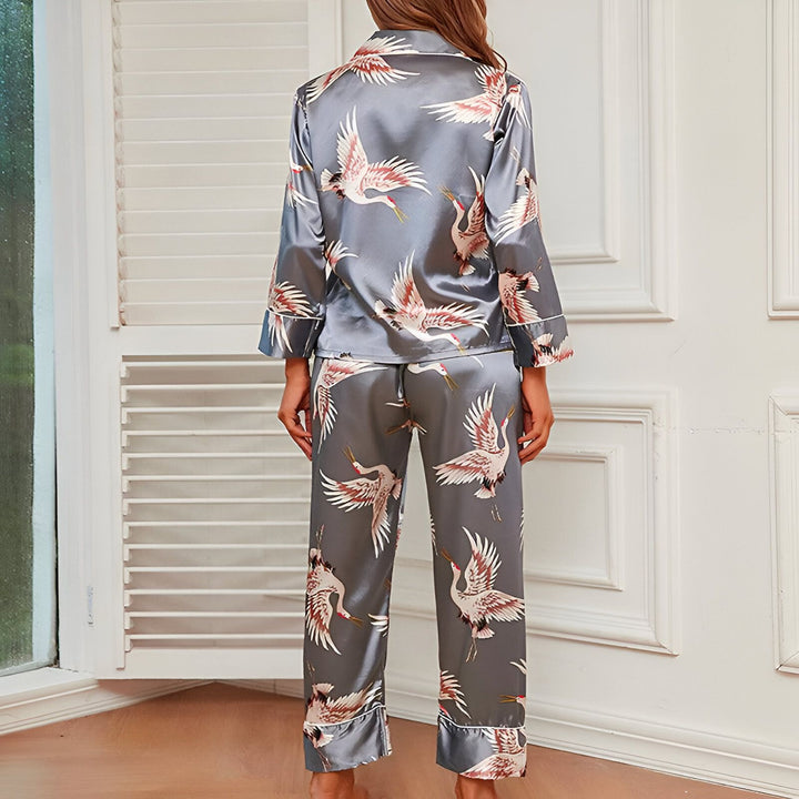 Femme portant un pyjama style kimono gris avec imprimé grues japonaises. Vêtements de nuit élégants et confortables. Notre collection de kimonos offre des designs uniques et de haute qualité.