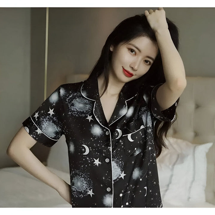 Femme portant un kimono noir imprimé avec des motifs de lune et d'étoiles, idéal comme vêtement de nuit ou d'intérieur. Découvrez notre collection de kimonos uniques.