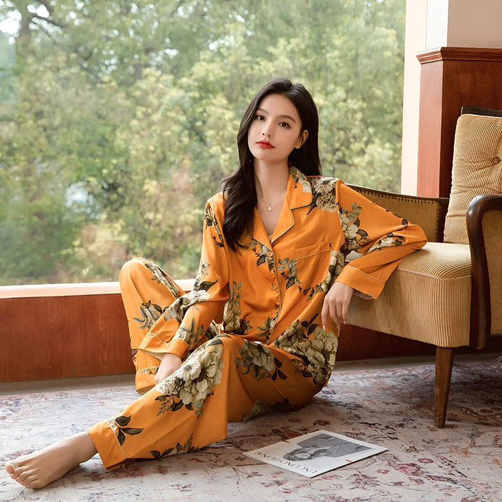 Femme assise portant un pyjama de style kimono orange avec des motifs floraux. Vêtements d'intérieur confortables et élégants.