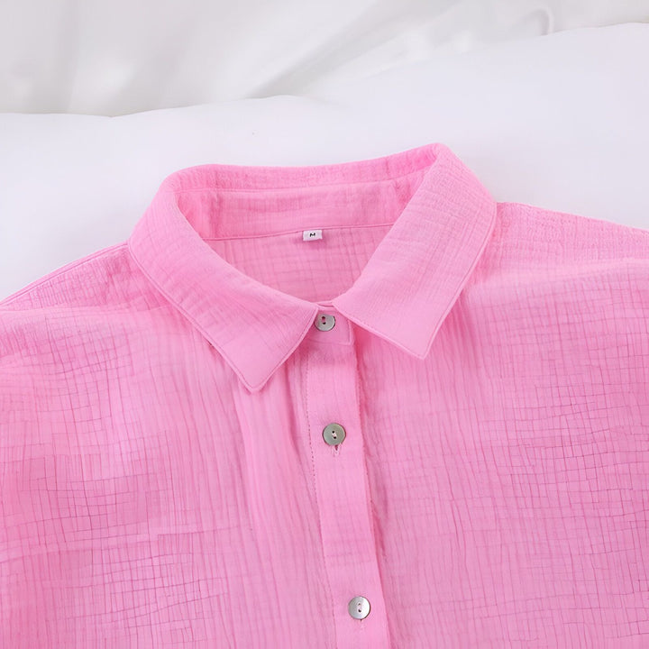 Détail d'une chemise de kimono rose en coton, avec un col classique et des boutons assortis. Parfait pour un look décontracté et élégant.