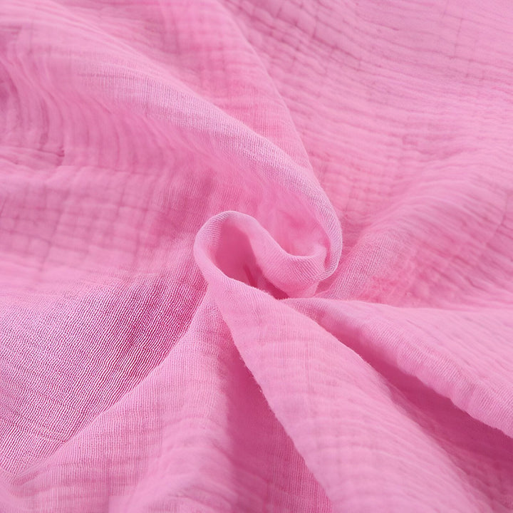 Tissu rose texturé, idéal pour la confection de kimonos légers et confortables. Détail de matière douce et fluide.