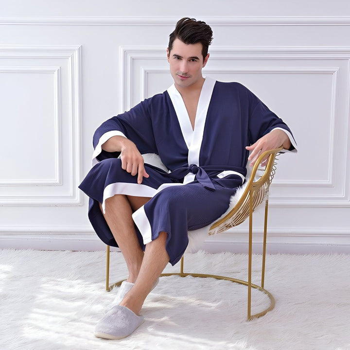 Homme portant un kimono bleu marine avec bordure blanche. Kimono confortable, parfait pour se détendre. Vente de kimonos en ligne.