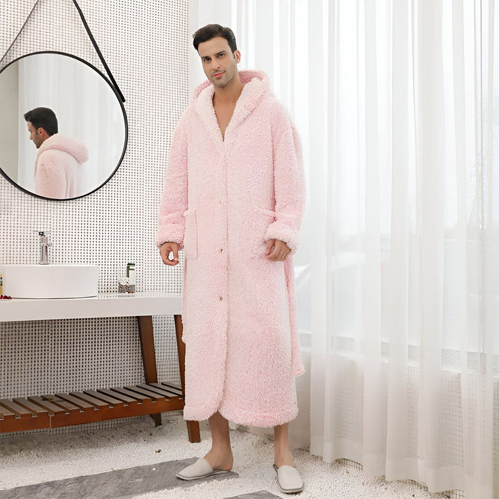 Homme portant un long peignoir kimono rose à capuche dans une salle de bain moderne. Kimonos doux et confortables à vendre.