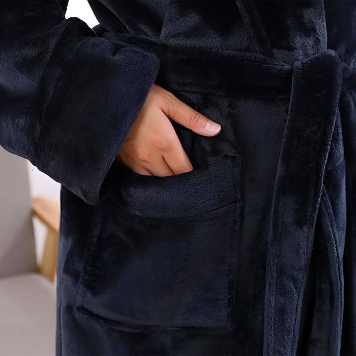 Gros plan sur un kimono bleu marine en tissu doux avec une main dans la poche. Ceinture assortie. Vêtements de détente, confortable et élégant. Notre collection de kimonos pour hommes et femmes.