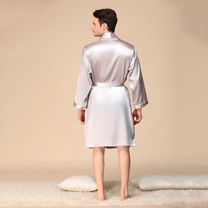 Homme portant un kimono en soie argentée. Vêtement de détente élégant, parfait comme peignoir ou robe de chambre. Découvrez notre collection de kimonos de luxe.