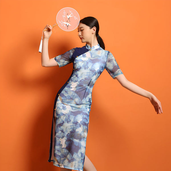 Femme portant un kimono à motifs bleus et blancs, tenant un éventail décoré de grues. Élégance et tradition asiatique, disponible dans notre collection de kimonos.
