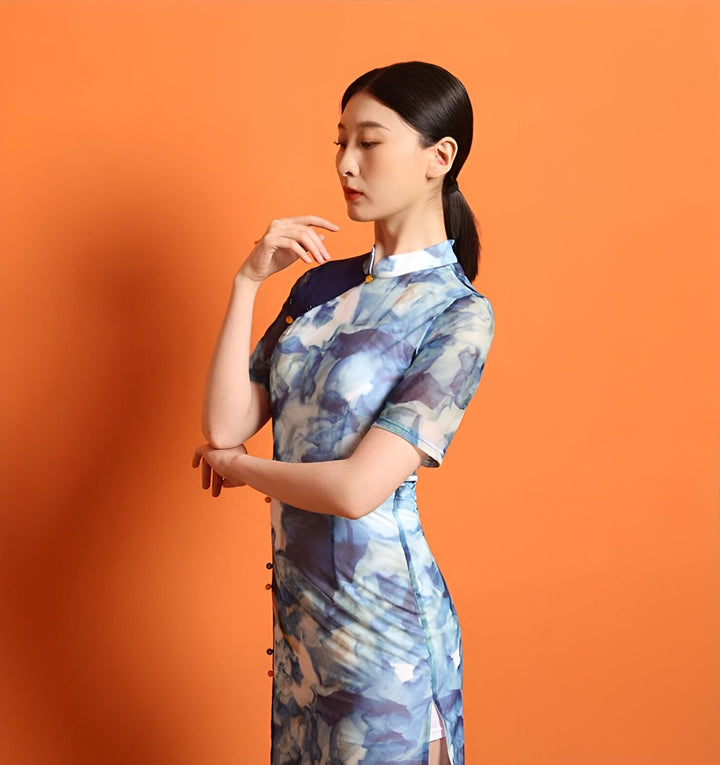 Femme portant un kimono bleu à motifs sur fond orange. Vêtements japonais traditionnels et modernes disponibles. Découvrez notre collection de kimonos uniques.
