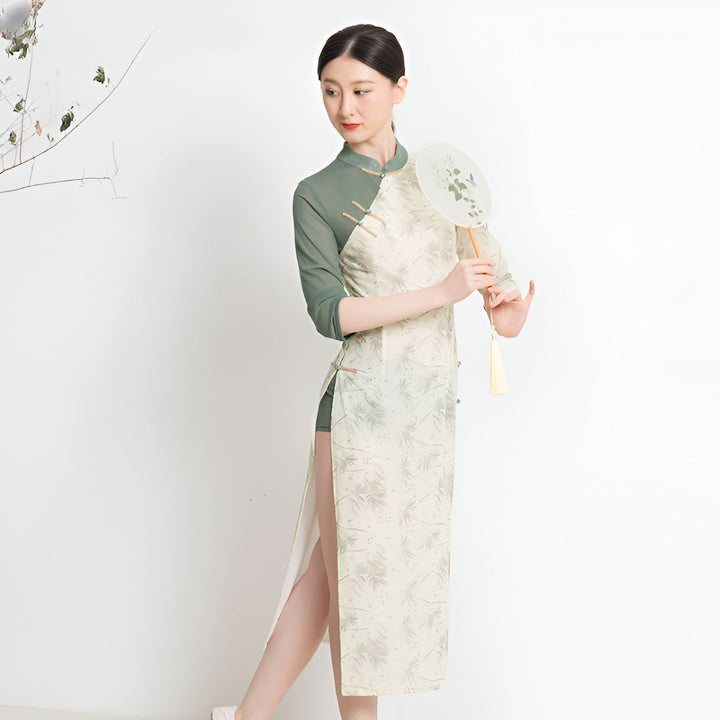 Femme portant un kimono long à motifs végétaux, vert et blanc. Elle tient un éventail. Découvrez notre collection de kimonos.
