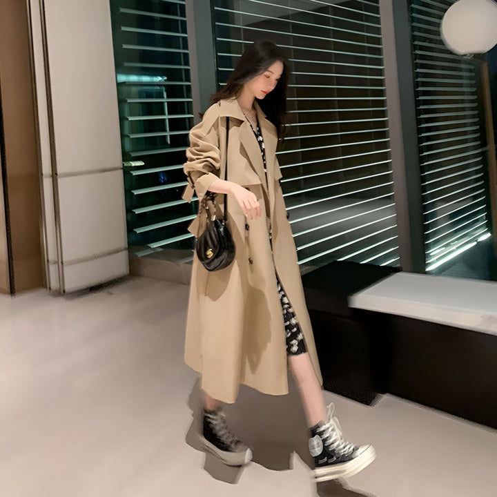 Femme portant un kimono beige élégant avec motifs floraux, accessoirisé d'un sac à main noir. Idéal pour un look traditionnel revisité. Découvrez notre collection de kimonos.