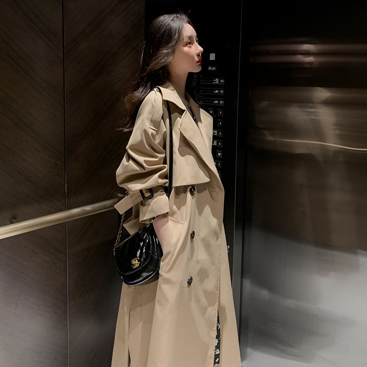 Femme portant un trench-coat beige, accessoire tendance pour compléter un kimono de notre collection. Mode femme, style élégant. Découvrez nos kimonos uniques.