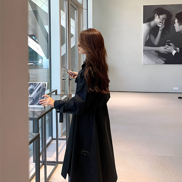 Femme portant un kimono noir élégant, regardant par la fenêtre. Collection de kimonos modernes, style unique et raffiné.