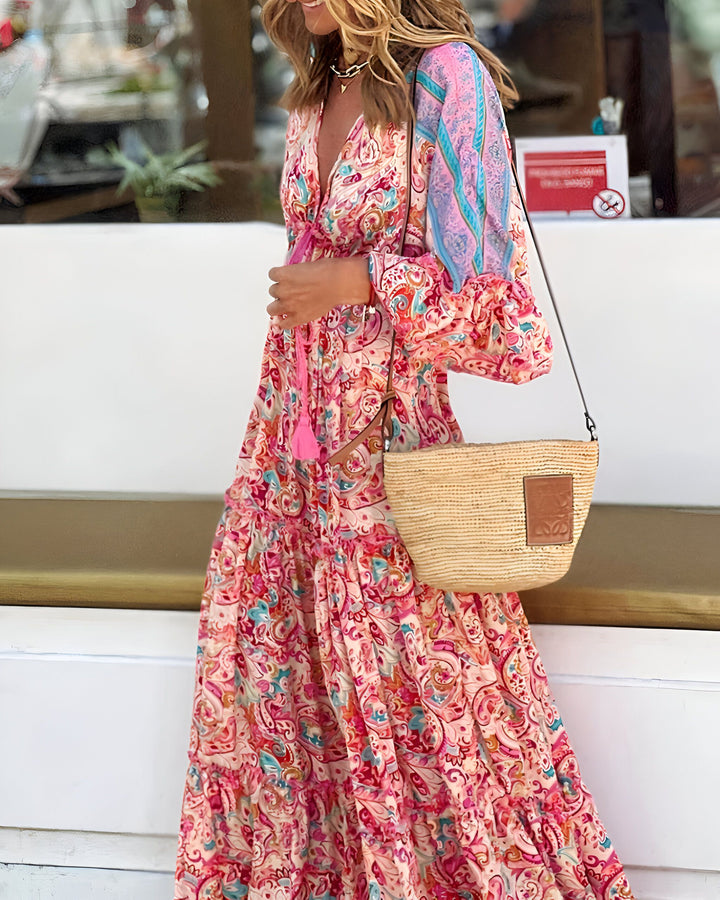 Femme portant une longue robe kimono à motifs colorés. Style bohème chic, manches longues évasées, décolleté plongeant. Sac en paille. Collection de kimonos.