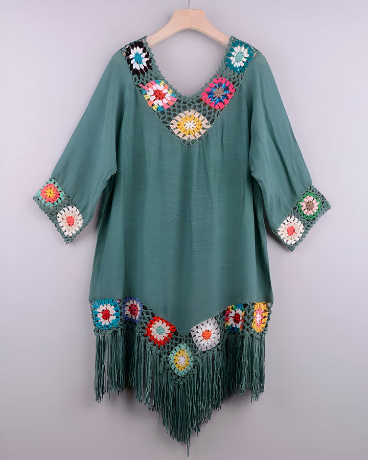 Kimono vert d'eau avec détails en crochet multicolore et franges, suspendu à un cintre. Vêtement bohème chic, idéal comme robe de plage ou tunique d'été. Collection de kimonos originaux.
