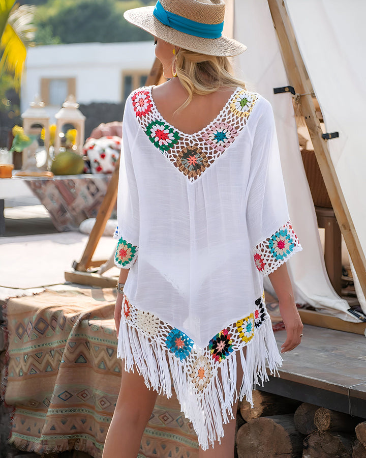 Femme portant un kimono blanc avec détails en crochet colorés et franges. Idéal comme vêtement de plage ou de détente. Découvrez notre collection de kimonos uniques.