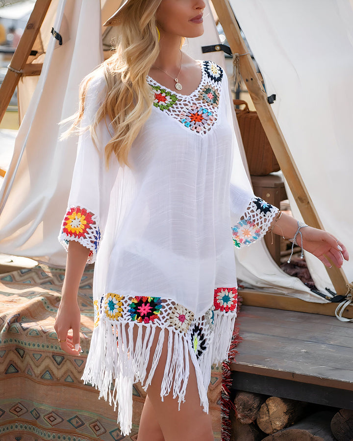 Femme portant un kimono blanc brodé de motifs floraux colorés. Idéal pour la plage ou comme vêtement d'été. Découvrez notre collection de kimonos.