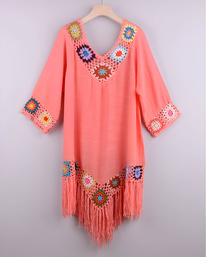 Kimono rose clair avec détails en crochet coloré et franges. Vêtement d'été idéal pour la plage ou comme paréo élégant.
