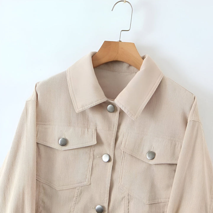 Veste beige style kimono sur un cintre. Veste en velours côtelé avec poches et boutons. Découvrez notre collection de kimonos.