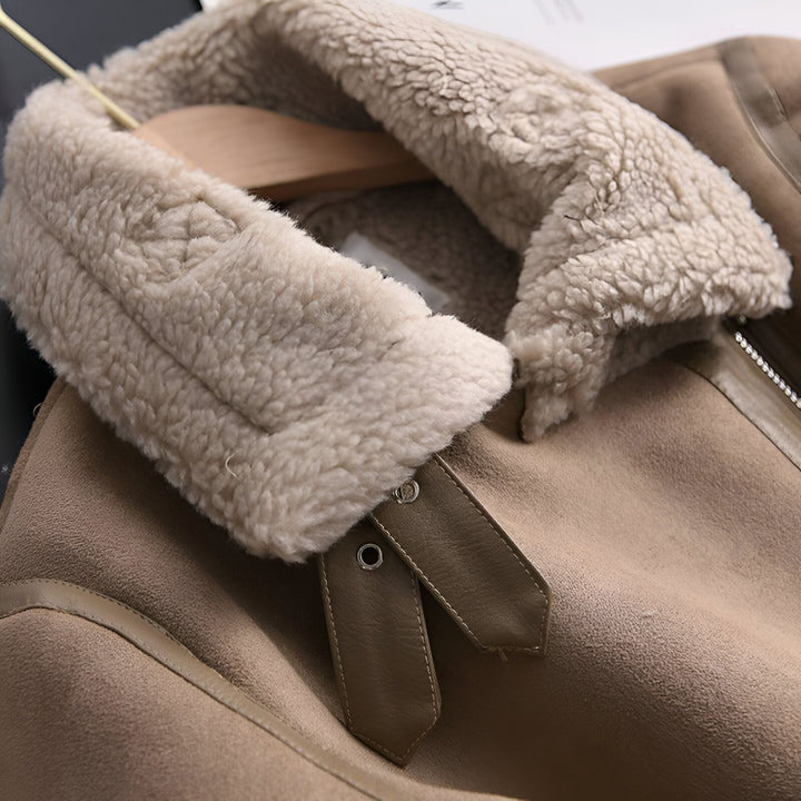 Détail d'un kimono en daim beige avec col en fausse fourrure sur un cintre. Texture douce et luxueuse. Parfait pour ajouter une touche d'élégance à votre garde-robe. Découvrez notre collection de kimonos uniques.