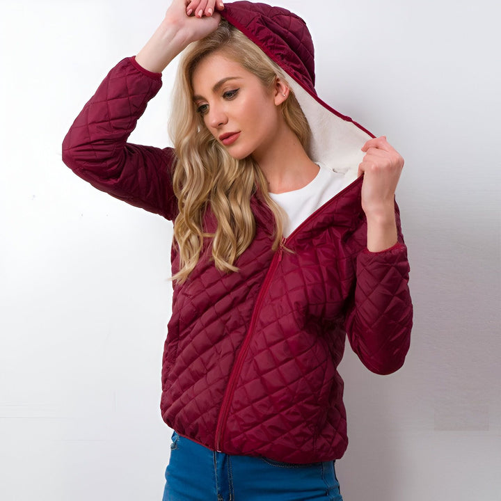 Femme portant une veste d'hiver bordeaux à capuche matelassée. Doublure intérieure en fausse fourrure blanche. Vêtements d'hiver confortables et élégants disponibles dans notre boutique de kimonos.