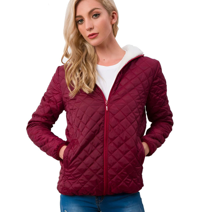 Femme blonde portant une veste matelassée bordeaux à capuche bordée de fausse fourrure blanche. Vêtements d'extérieur confortables. Explorez notre collection de kimonos uniques.