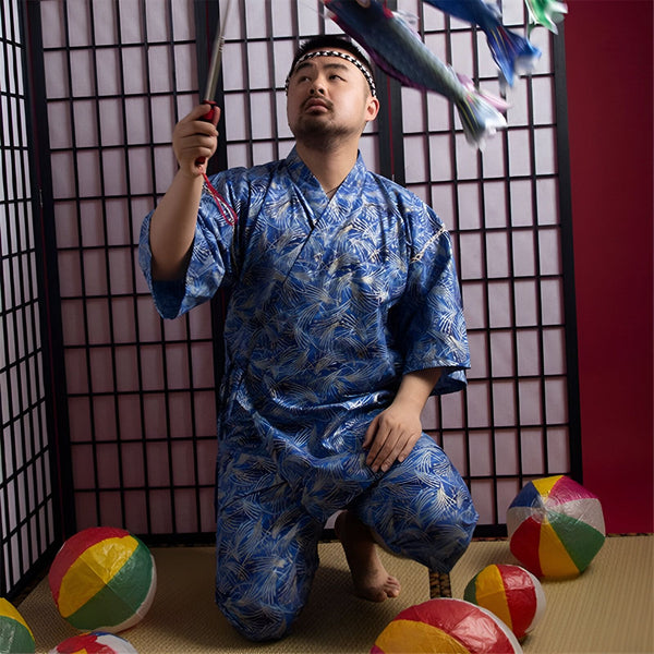 Homme en kimono bleu à motifs, agenouillé, tenant une perche avec des carpes volantes. Vente de kimonos japonais authentiques.