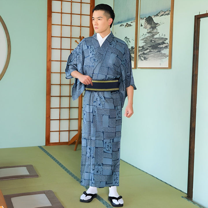Homme portant un kimono japonais traditionnel bleu à motifs dans un intérieur japonais. Kimono pour hommes à vendre.