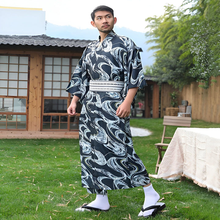 Homme asiatique portant un kimono traditionnel noir avec motifs blancs et obi. Kimonos à vendre sur [Nom de votre boutique].