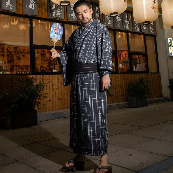 Homme en kimono traditionnel japonais à carreaux, tenant un éventail. Vente de kimonos authentiques.