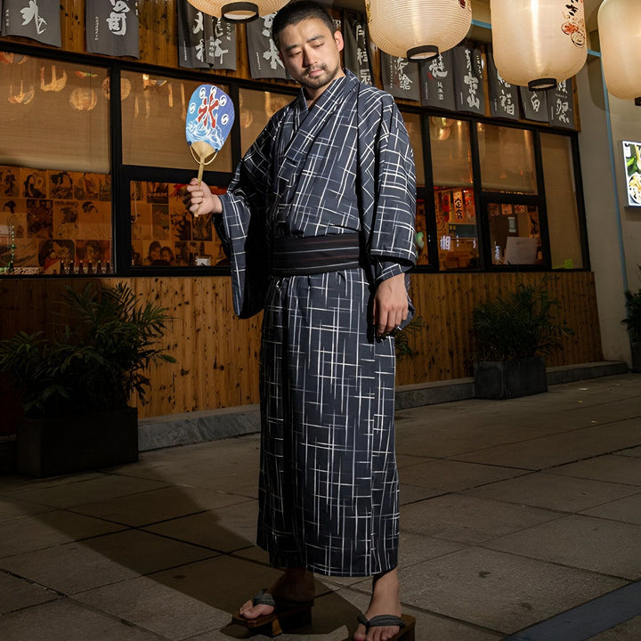Homme en kimono traditionnel japonais à carreaux, tenant un éventail. Vente de kimonos authentiques.