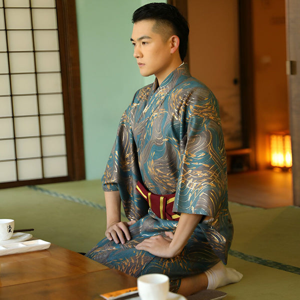 Homme en kimono agenouillé. Kimono bleu et or de style japonais. Vêtements traditionnels japonais à vendre.