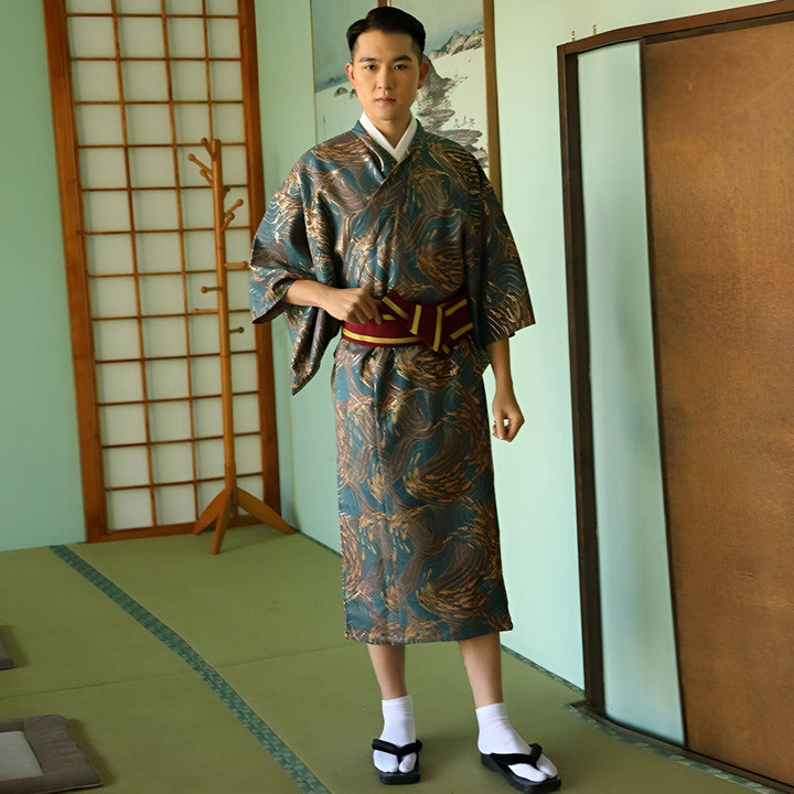 Homme portant un kimono japonais traditionnel avec des motifs dorés et une ceinture obi rouge. Vente de kimonos authentiques en ligne. Découvrez notre collection de kimonos de haute qualité.
