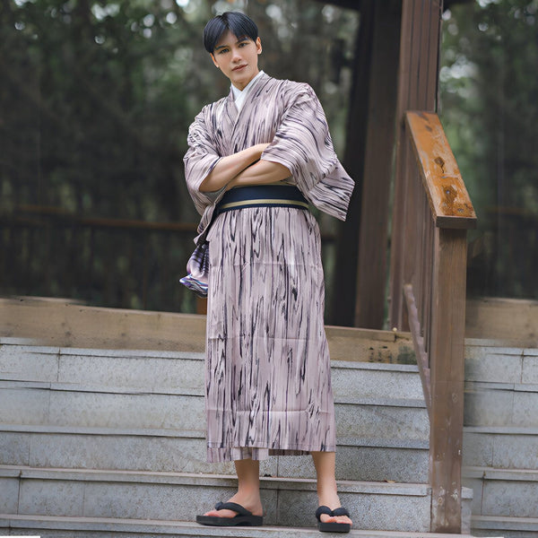Homme portant un kimono traditionnel japonais à motifs sur des marches. Kimonos à vendre.