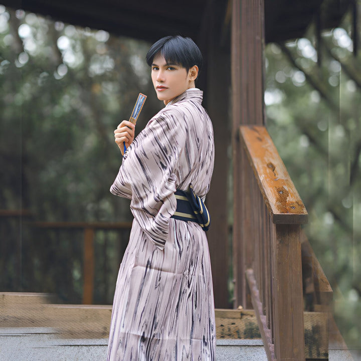 Homme portant un kimono japonais traditionnel à motifs, tenant un éventail. Kimonos en vente.
